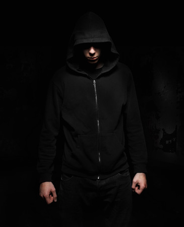 Hooded incognito silhouette isolated on black の写真素材