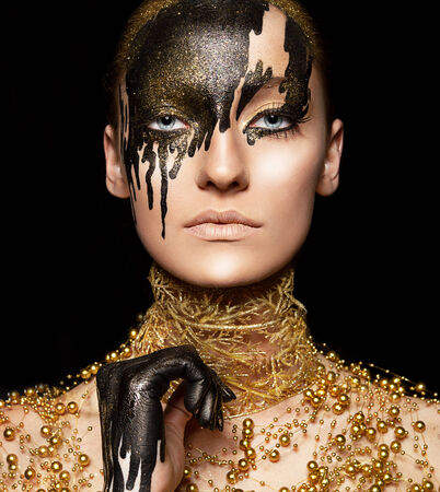 Ceremonial visage imagination Portrait of beauty woman in golden style with painted faceの写真素材