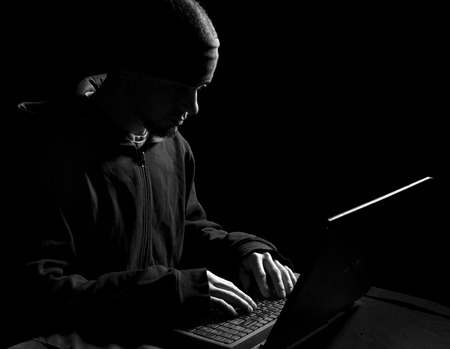 Silhouette of a hacker uses a command on graphic user interface の写真素材
