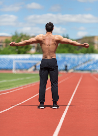 Warming-up.Athlete doing exercises at stadiumの写真素材