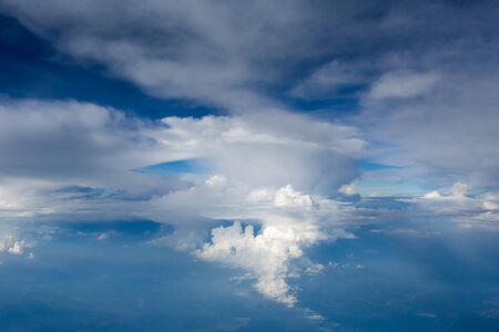 Aerial view on clouds and blue sky from airplane windowの写真素材