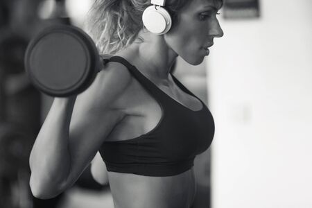 fitness,powerlifting and sport lifestyle concept - sporty woman exercising with barbell in gymの写真素材