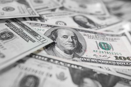 A pile of Five, Ten and One hundred US dollar bills on a tableの写真素材