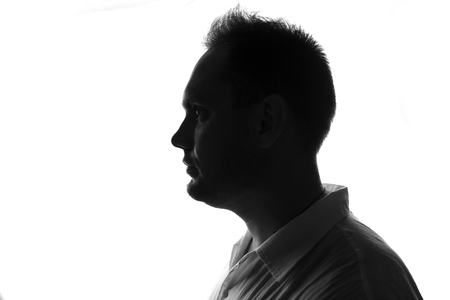 Male person silhouette,back lit over whiteの写真素材