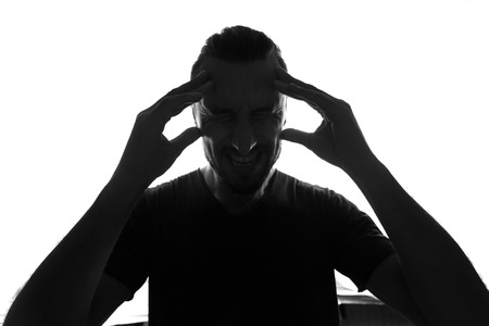 Frustrated man with headache-silhouette isolated over white