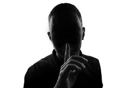 Male person silhouette gesture finger on lipsの写真素材