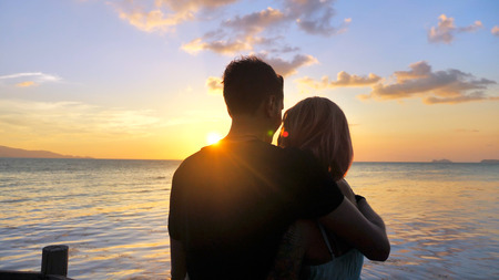 Beautiful Young Couple in Love Hug at Sunset time with Sea viewの写真素材