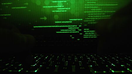 Cyber hacker attack data secure in spy typing on laptop keyboardの写真素材
