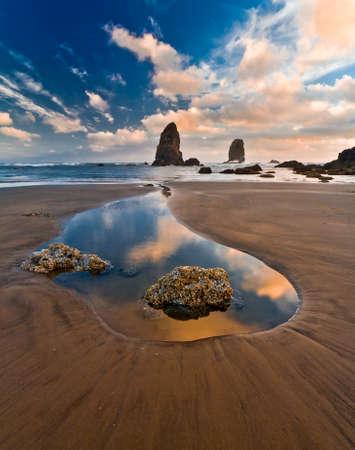 Quiet summer sunset at Cannon Beach, Oregon, USA - wet sand, clouds reflections in the water.の写真素材