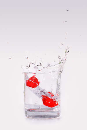 Splash in a glass of water on grey