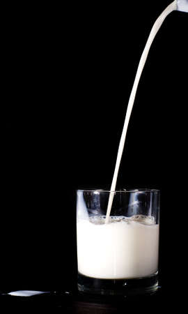 Milk pouring into the glassの写真素材