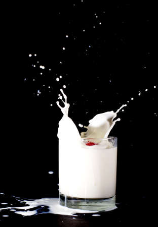 Milk in a glass splashingの写真素材
