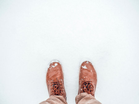 Time to buy winter shoes. Top view man standing in the snow. Boots in pure snow. Banner background with copy spaceの写真素材