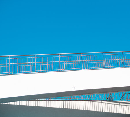 Multilevel low angel wheelchair ramp bridge for disabled on a clear sky background. Urban accessibility for people with disabilitiesの写真素材