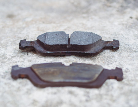 Comparing new and old worn brake pads from car braking system. Lack of proper maintenance of the car can lead to an accidentの写真素材