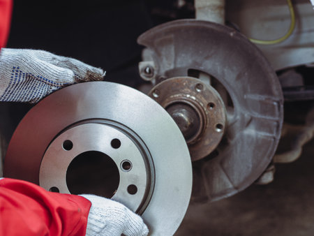 Process of replacing brake discs with Brand new. Auto mechanic repairing in garage Car brakesの写真素材