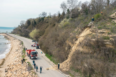 14 april 2023 Varna, Bulgaria: Landslides and rockfalls on the road in the forest. Aerial view: mud and rocks blocking the road after rain. The fire brigade eliminates the threat of another collapseのeditorial素材