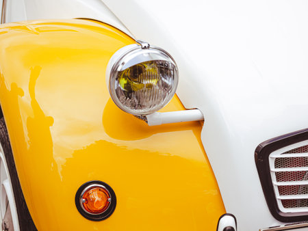Classic retro car with close-up on headlights. Summer hot car parked on a beach.