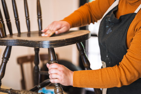 Slow motion furniture restoration. Sanding wooden chair before paintの写真素材
