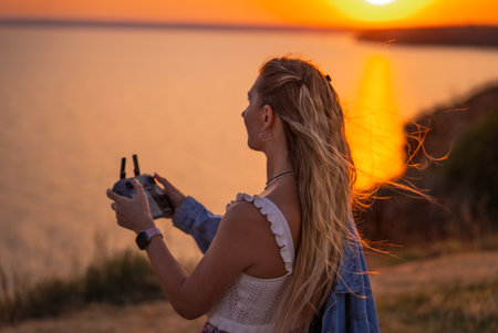 Young Woman Piloting Drone Over Ocean at Sunset