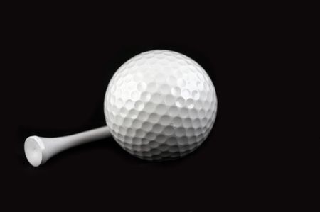 golf ball and golf tee on black backgroundの写真素材