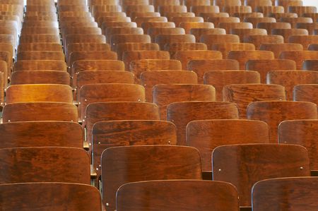 rows of wood chairs in an old auditoriumの写真素材