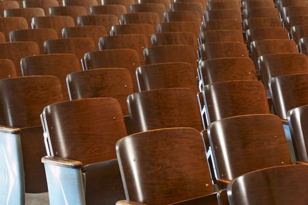 rows of wood chairs in an old auditoriumの写真素材