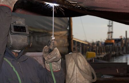 a welder working at shipyard under vesselの写真素材