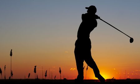 a silhouette of a golfer on a bright skyの写真素材