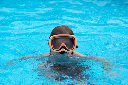 a young boy in pool with goggles onの写真素材