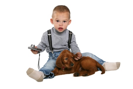 The boy siting with a puppy and the camera on a white backgroundの写真素材