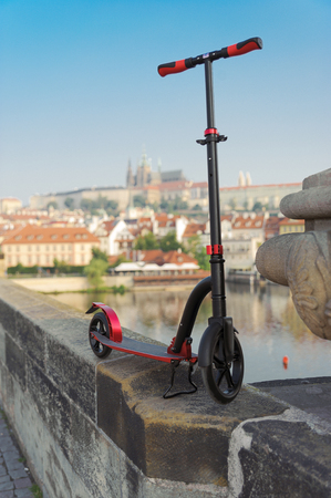 Red push scooters against the backdrop of the Charles Bridge in the Prague, Czech Republic. Vertical.の写真素材