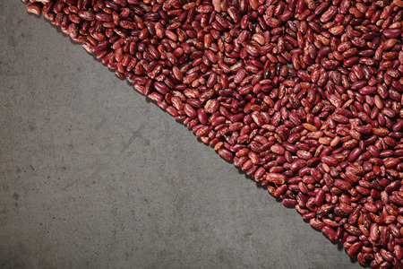 Pattern with red beans on grey background. Horizontal. Top view.