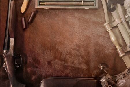 Hunting concept with woodcock, shotgun, knife and ammunition for hunting arranged on brown...