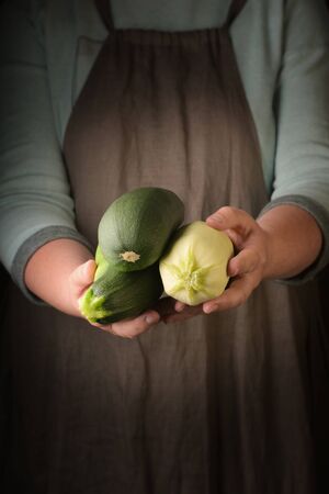 Organic fresh harvested vegetables. Farmers hands with fresh marrow, closeup.の写真素材