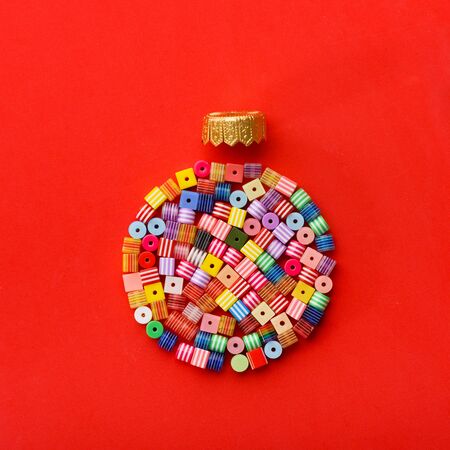Christmas Bauble made of decoration elements on red background. Flat lay. Contemporary design....