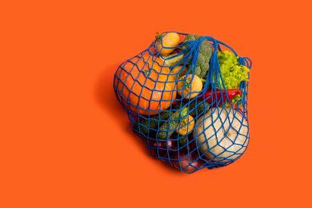 Mesh textile bag full of mixed vegetables. Healthy food and zero waste concept.の写真素材
