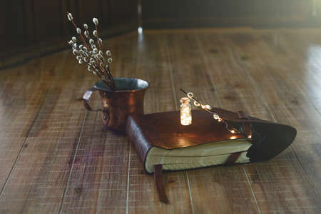 Antique book and willow twigs lie on a wooden table. Close-up.の写真素材