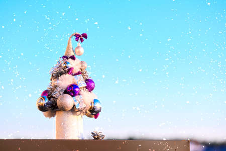 A small decorative decorated Christmas tree on the background of the sky. High quality photoの写真素材