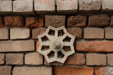 Metal element on an old brick wall. Close-up.