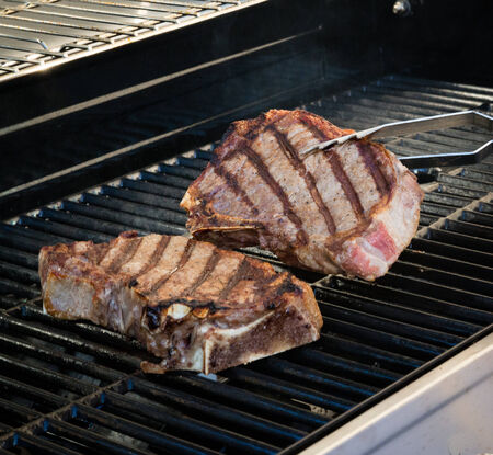 Cooking steaks on the grill の写真素材
