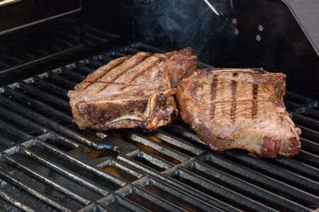 Cooking steaks on the grill の写真素材