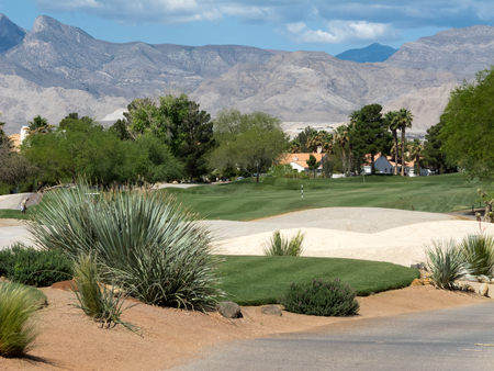 Beautiful Las Vegas golf course surrounded by mountains with a blue sky and beautifully manicured fairways and greens の写真素材