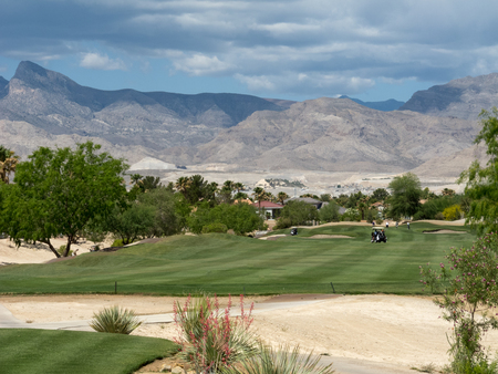 Beautiful Las Vegas golf course surrounded by mountains with a blue sky and beautifully manicured fairways and greens の写真素材