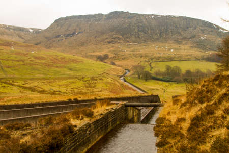 Water overflow at Dovestone reservoir with hills in the background