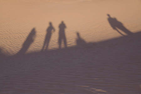 Tourists cast shadows in the Saharan Desertの写真素材