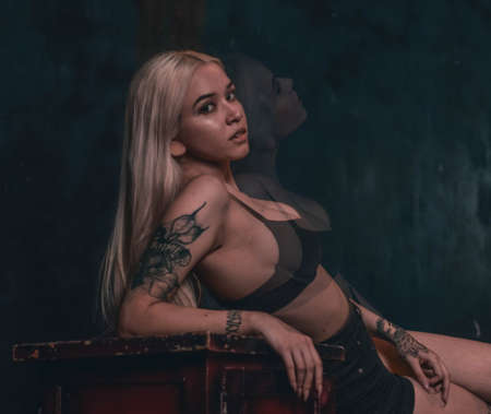 Fashion, sexy girl in a bra sits on a chair