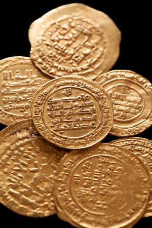 Ancient golden islamic coins with arabic letters, closeup macro shot, selective ficus, verticalの写真素材