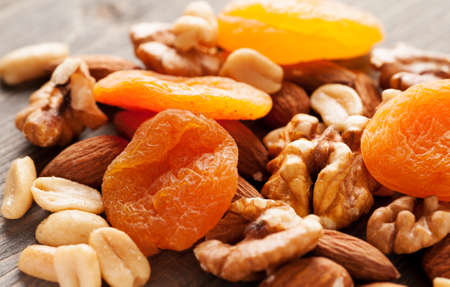 Dried apricots with nuts on wooden table close-up macro shotの写真素材