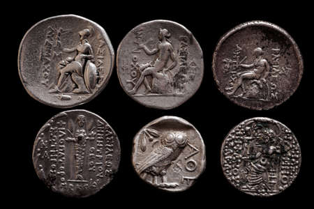 Two rows of ancient greek silver coins on a black background, closeup macro shot, selective focusの写真素材